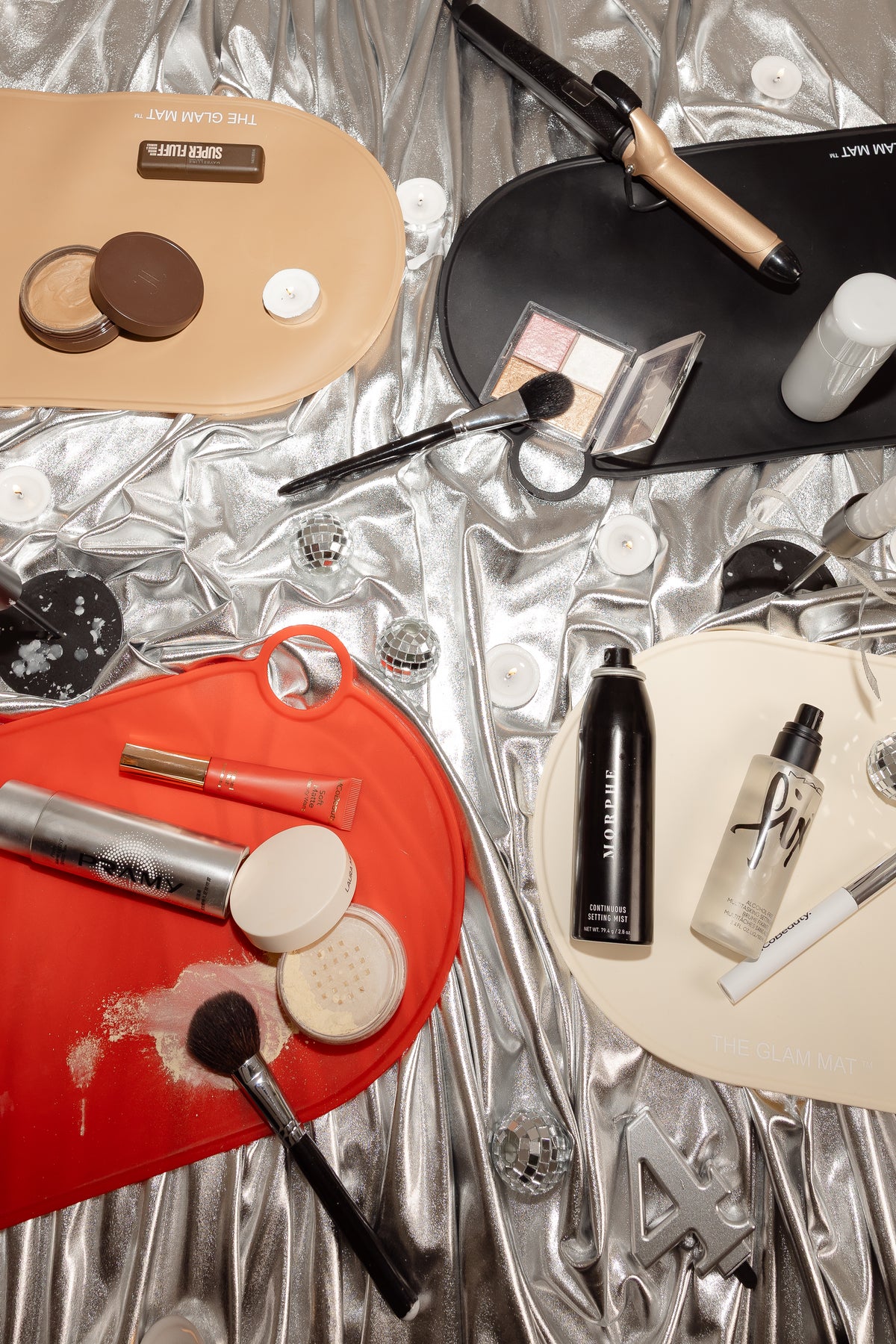 The Glam Mat rolled and laid out beside a makeup artist's kit